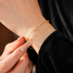 Detailaufnahme der vergoldeten Kleeblatt-Armband und Schlangenkette mit Zirkonia