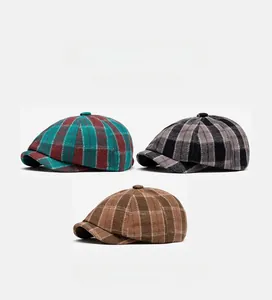 Detailed view of three checkered newsboy caps in red, black, and brown wool textures