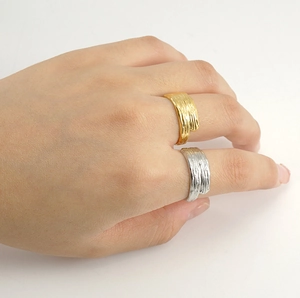 Adjustable stainless steel rings with gold and silver irregular bark texture on finger