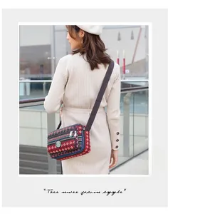 Detail of bohemian striped canvas crossbody bag with multi-layer zipper compartments