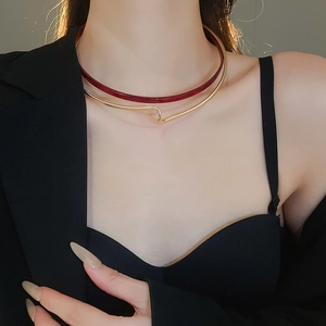 Detail of double-layer choker with burgundy resin ring and golden wavy metal wire