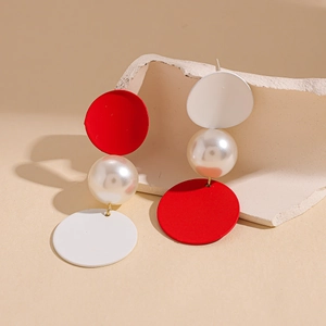 Detailed macro view of asymmetric red matte finish earring with large faux pearl accent