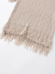 Detail eines beigen Strickoberteils mit Fransenbesatz und strukturierter Bouclé-Optik