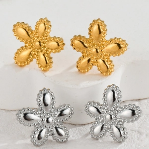Irregular textured flower stud earrings in gold and silver finish on white stone