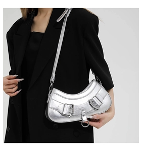 Close-up of silver crescent bag with metallic cracked texture and buckle details