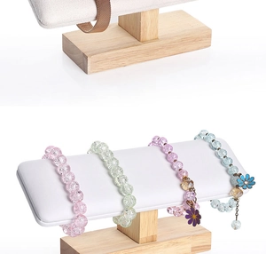 Macro detail of solid wood jewelry stand with soft white leather crossbar for bracelets