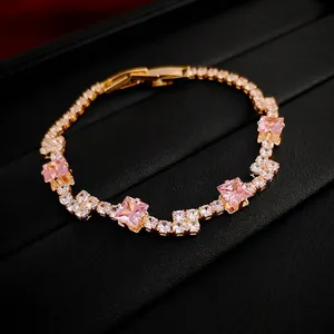 Elegant gold-tone bracelet featuring five pink square zircons and white rhinestone accents