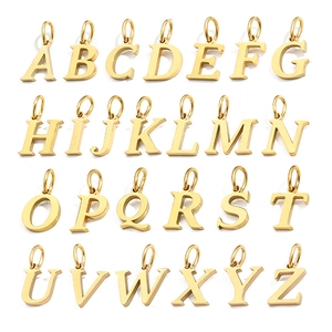 Flat lay of 26 gold alphabet pendants A-Z for DIY jewelry making on white background