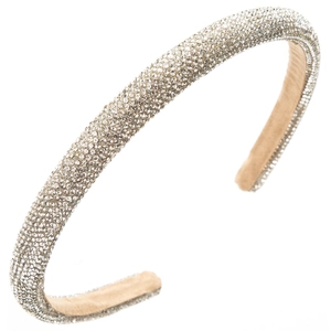 Makro-Detail eines luxuriösen Haarreifs mit glänzenden Silber-Strasssteinen auf beige Band