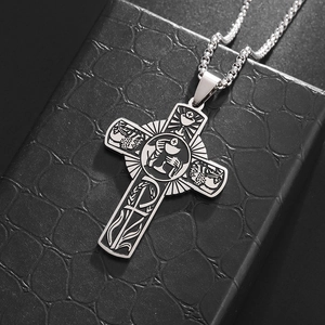 Silver stainless steel cross necklace with religious engraving on a black textured gift box