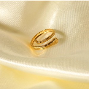 Detail of 18K gold-plated snake skin textured adjustable ring on champagne silk fabric