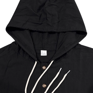 Close-up of the linen hooded shirt collar with visible fabric texture and size label