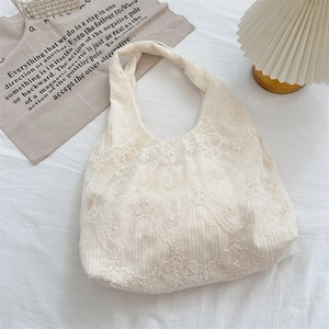 Macro detail of intricate white floral lace patterns on a Korean style shoulder tote bag
