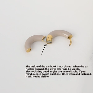 Macro view showing the internal opening mechanism of the beige enamel hoop earrings