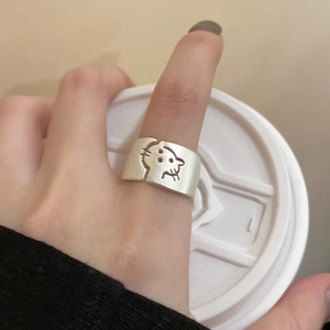 Detail of silver hollow wave ring with cartoon leopard motif worn on the finger