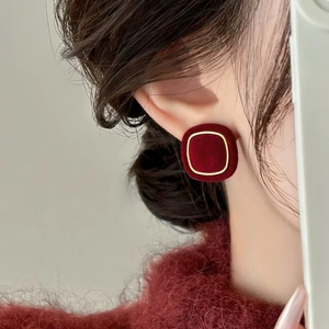 Elegant wine red velvet square stud earrings with gold border on model ears