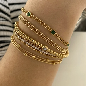 Five-piece stacked gold plated stainless steel bracelet set with green emerald gems