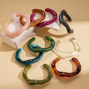 Irregular wavy acrylic cuff bracelets in various colors with a modern artistic design