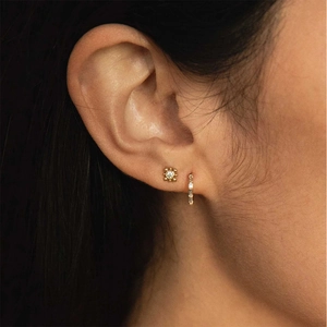 Close-up of S925 silver gold-plated huggie hoop with square cubic zirconia on ear