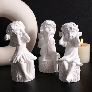 Three little girl statues sitting on stumps in see-hear-speak no evil poses