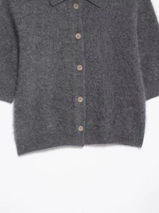 Detail of grey mohair knit cardigan showing soft wool texture and round button fasteners