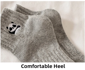 Detailed macro view of gray cotton socks with cute panda embroidery and ribbed knit texture