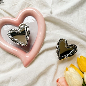 Chic silver heart mirror phone grip with ruffled wave edges on a romantic vanity setting