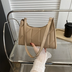 Quilted beige baguette bag with geometric stitching and top zipper handle
