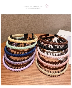 Close-up of colorful braided non-slip headbands for girls on a warm wooden table