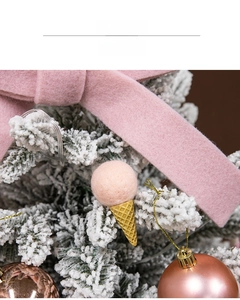 Pink wool felt ice cream and bow ornaments hanging on a white flocked Christmas tree branch