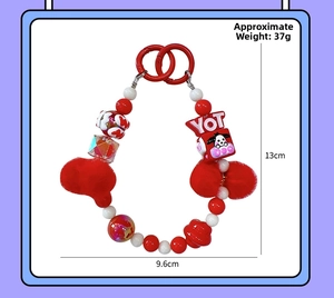 Detail van rood-witte kralenhanger met pluche ballen en YOT-kubus, 13cm bij 9,6cm