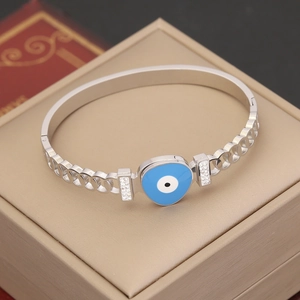 Silberner Evil-Eye-Armreif mit blauer Emaille und funkelnden Kristallen auf Schmuckbox
