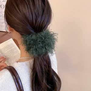 Detailed close-up of a dark green faux fur hair scrunchie styled on a ponytail hair