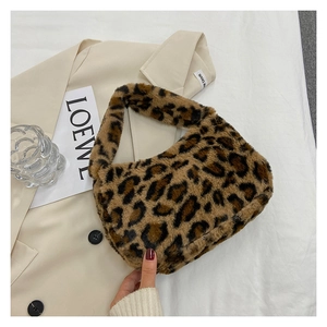 Detail of leopard print faux fur handbag held against a beige coat for a stylish look