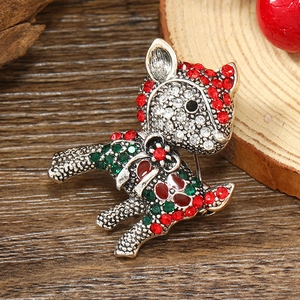 Macro shot of silver deer brooch with red and green rhinestones and enamel details