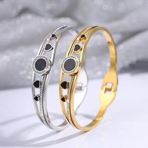 Detail showing gold and silver titanium heart bracelets with rhinestones and black enamel