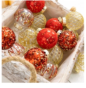Macro view of assorted 6-8cm red and gold Christmas baubles in a rustic wooden box