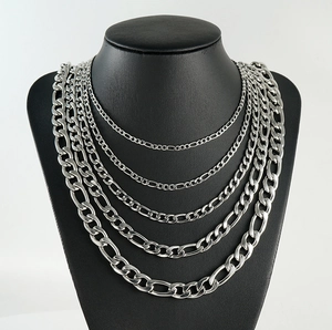 Macro detail of silver Figaro chains in various widths on a black jewelry bust display