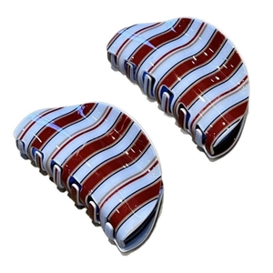 Close-up of blue and brown striped acetate hair claw clips with wavy pattern detail