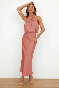 Detail of elegant coral pink satin dress featuring a cowl neck and halter design