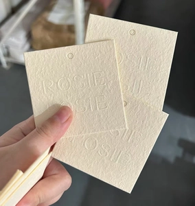 Close-up of beige paper jewelry display cards with embossed ROSIE SIE logo texture
