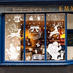 White Christmas window stickers featuring Santa Claus and reindeer on a store glass