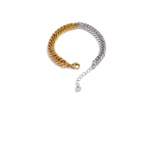 Detailed shot of two-tone gold and silver stainless steel chain with lobster clasp and charm