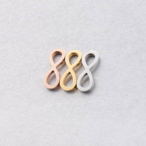 Macro shot of infinity symbol pendants in rose gold, gold and silver finishes