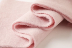 Détail macro de l'écharpe en mohair rose montrant la texture épaisse et duveteuse