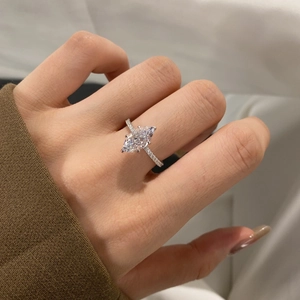 Close-up of marquise-cut silver ring with pave-set side stones on a finger