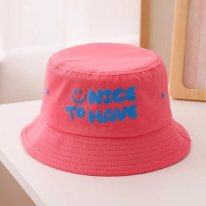 Détail du chapeau de soleil rose en coton avec texte NICE bleu en relief et sourire