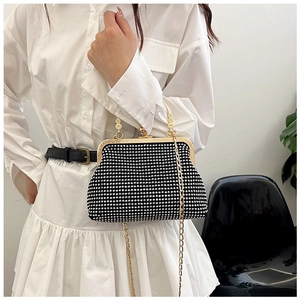 Close-up of black and white rhinestone evening bag with gold handle and chain detail