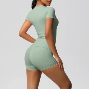 Close-up of seamless light green yoga set showing high-waist shorts and slim-fit top texture