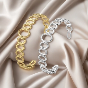 Elegant gold and silver link open bangles with geometric hollow design on silk background
